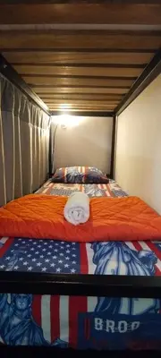 a bedroom with a bed with a doll on it at Hostel Metro Floresta Alojamiento in Medellín