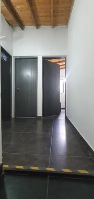 an empty room with two doors and a tile floor at Hostel Metro Floresta Alojamiento in Medellín