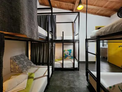a room with three bunk beds in a house at Hostel Metro Floresta Alojamiento in Medellín