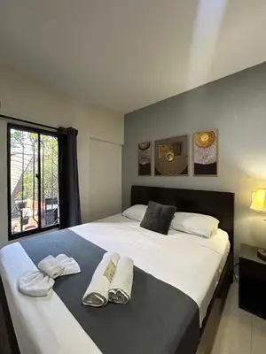 a bedroom with a large bed with two pairs of slippers at Balcón Paisa SAS in Medellín