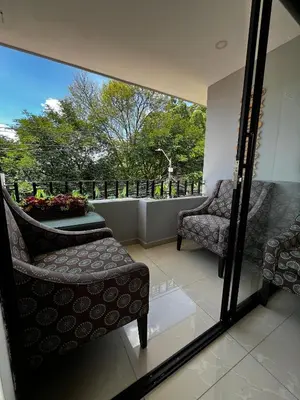 a balcony with two chairs and a table and a window at Balcón Paisa SAS in Medellín