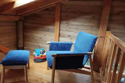 two blue chairs in a room with wooden walls at La Casa En El Bosque in El Retiro