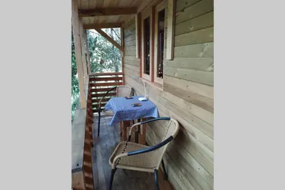 a table and chairs on the porch of a cabin at La Casa En El Bosque in El Retiro