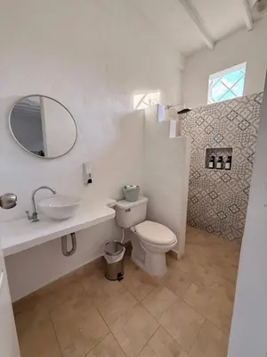 a bathroom with a toilet and a sink and a mirror at Cabaña Doradal MILOS in Puerto Triunfo