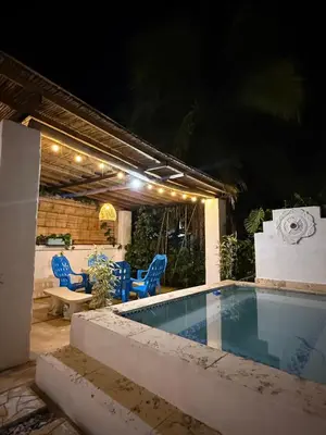 a swimming pool at night with blue chairs around it at Cabaña Doradal MILOS in Puerto Triunfo