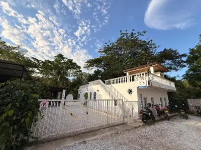 a white house with a motorcycle parked in front of it at Cabaña Doradal MILOS in Puerto Triunfo