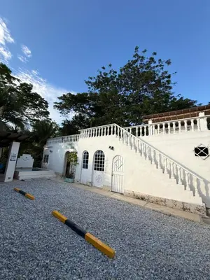 a white building with a staircase and two baseball bats at Cabaña Doradal MILOS in Puerto Triunfo