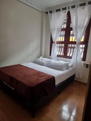 a bedroom with a bed with a window with curtains at HOSPEDAJE EN ESPLENDOR in Jardin