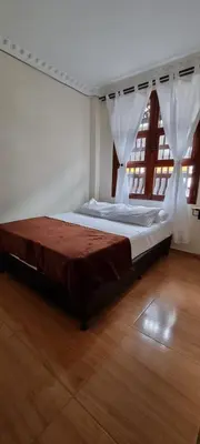 a large bed in a room with a wooden floor at HOSPEDAJE EN ESPLENDOR in Jardin