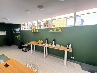 a table in a room with a green wall at Poblado Park Guest House in Medellín