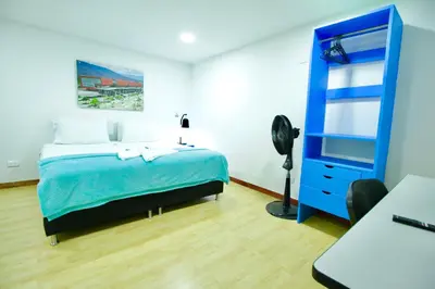 a bedroom with a blue bed and a blue dresser at Poblado Park Guest House in Medellín