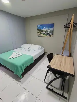 a bedroom with a bed and a table and a chair at Poblado Park Guest House in Medellín