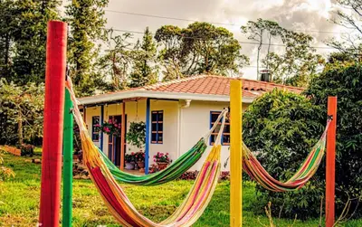 a house with a hammock in front of a house at Génesis, un lugar para descansar y disfrutar in Santa Elena