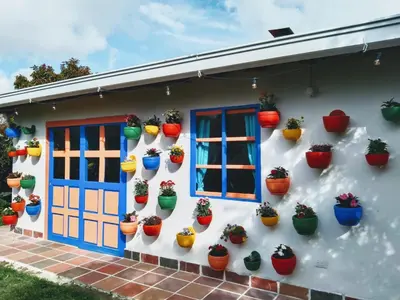 a house with potted plants on the wall at Génesis, un lugar para descansar y disfrutar in Santa Elena
