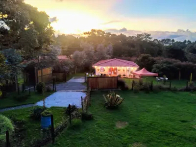 a view of a garden with a house in the background at Génesis, un lugar para descansar y disfrutar in Santa Elena