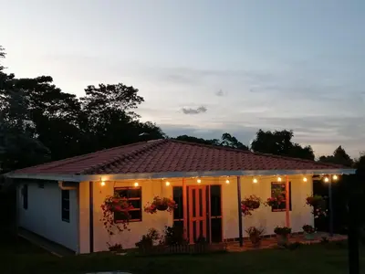 a small white house with lights on it at Génesis, un lugar para descansar y disfrutar in Santa Elena