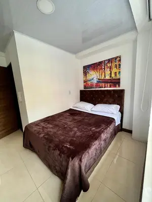 a bedroom with a large bed with a painting on the wall at Amarena Hotel Boutique in Manizales