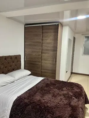 a bedroom with a large bed with a wooden closet at Amarena Hotel Boutique in Manizales