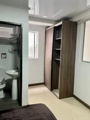 a bathroom with a toilet and a wooden door at Amarena Hotel Boutique in Manizales