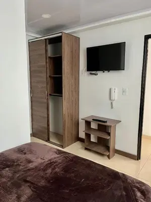 a room with a tv on a wall with a desk at Amarena Hotel Boutique in Manizales