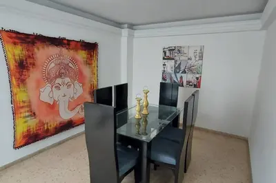 a dining room with a glass table and a painting at Amplio Apartamento en Los Colores in Medellín