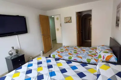 a bedroom with a bed and a flat screen tv at Amplio Apartamento en Los Colores in Medellín