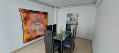 a dining room with a table and a painting on the wall at Amplio Apartamento en Los Colores in Medellín