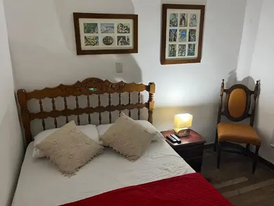 a bedroom with a bed with a lamp and a chair at Casa Grande in Medellín