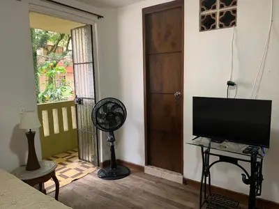 a living room with a flat screen tv and a fan at Casa Grande in Medellín