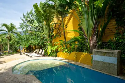 a swimming pool in front of a house with plants at Encomendero Hotel -Centro Histórico- in Santa Fe de Antioquia