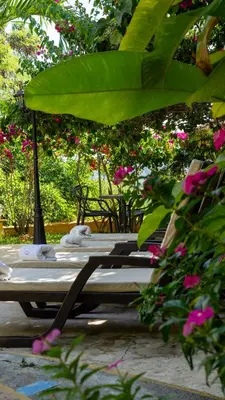 two chaise lounges sitting under an umbrella at Encomendero Hotel -Centro Histórico- in Santa Fe de Antioquia