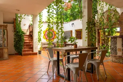 a table and chairs in a room with plants at Encomendero Hotel -Centro Histórico- in Santa Fe de Antioquia
