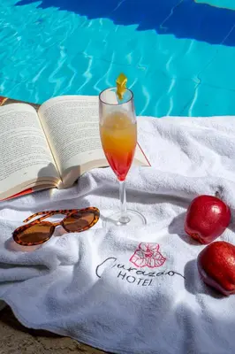 a book and a glass of orange juice and a drink at Curazao Hotel -Centro Histórico- in Santa Fe de Antioquia