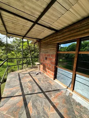an outside patio with a table and windows at Cabañas San Jose in Doradal