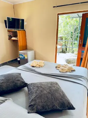 two beds in a room with towels on them at Cabañas San Jose in Doradal