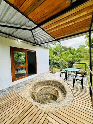 a patio with a fire pit and a table on a deck at Cabañas San Jose in Doradal
