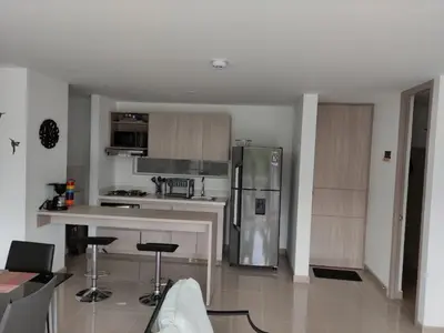 a kitchen with a refrigerator and some bar stools at Casitadisol in Santa Fe de Antioquia