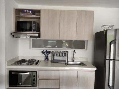 a kitchen with a sink and a microwave at Casitadisol in Santa Fe de Antioquia