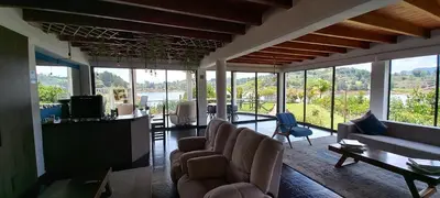 a living room with couches and chairs and windows at Jordan Hotel Boutique in Guatapé