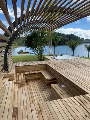a wooden deck with a bench on top of a lake at Jordan Hotel Boutique in Guatapé