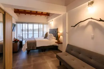 a bedroom with a bed and a couch at Jordan Hotel Boutique in Guatapé