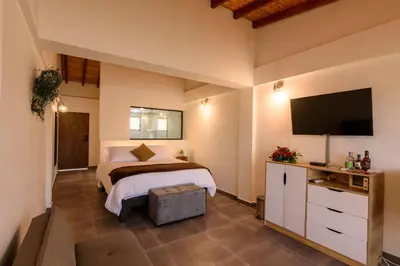 a bedroom with a bed and a flat screen tv at Jordan Hotel Boutique in Guatapé
