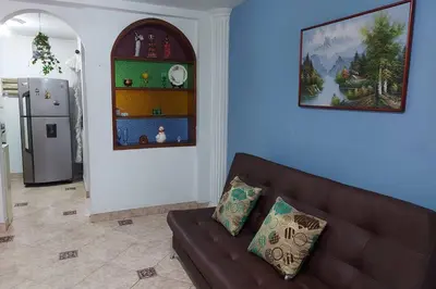a living room with a brown couch and a refrigerator at Apartamento cerca Mall La Central y Estación Tranvía in Medellín