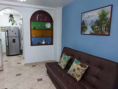 a living room with a brown couch and a refrigerator at Apartamento cerca Mall La Central y Estación Tranvía in Medellín