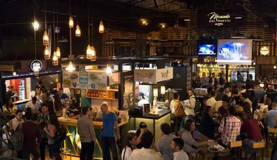 a crowd of people standing around a bar in a restaurant at Apartamento cerca Mall La Central y Estación Tranvía in Medellín
