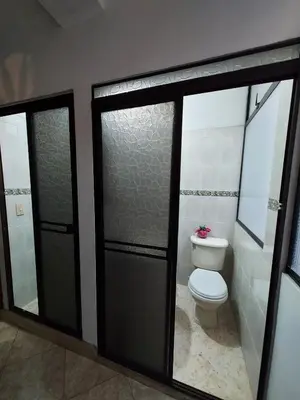 a bathroom with a toilet and two glass doors at Apartamento cerca Mall La Central y Estación Tranvía in Medellín
