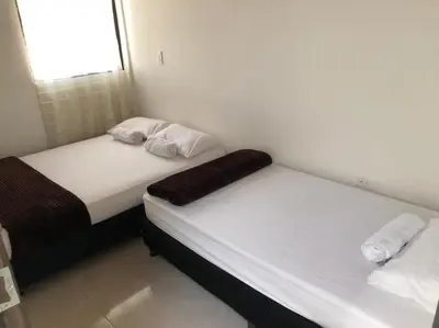 two beds in a small room with white walls at El EmAnJe 1 in Jardin