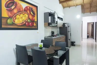 a dining room with a table and a painting of fruit at El EmAnJe 1 in Jardin