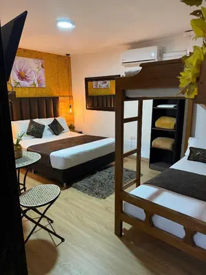 a room with two bunk beds and a table and chairs at The Garden Lleras 10 in Medellín