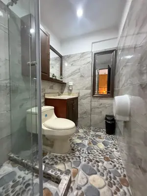 a bathroom with a toilet and a glass shower at The Garden Lleras 10 in Medellín